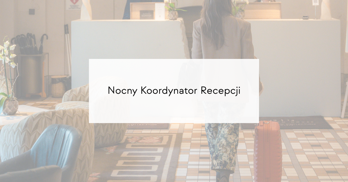 Person with a rolling suitcase walks toward a hotel reception desk in a bright lobby (back view).